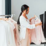 Conception of fashion. Seamstress is in her office that is with different clothes