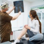 Doctor examines x-ray of patient leg. Foot and sprain concept. Sport exercise injuries.