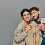 fall season, smile, romantic couple hugging on grey background, trench coats, style, romance
