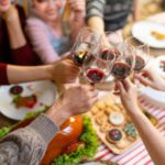 Happy family toasting with wine on Christmas eve. Multiracial family are celebrating holiday.