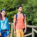mixed race couple trekking in senda del oso, Asturias. Mid adult ecotourism in Proaza