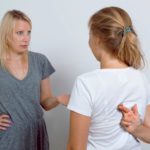 Mother asking her teenage daughter. Girl wants to lie to her parent and crossed her fingers.