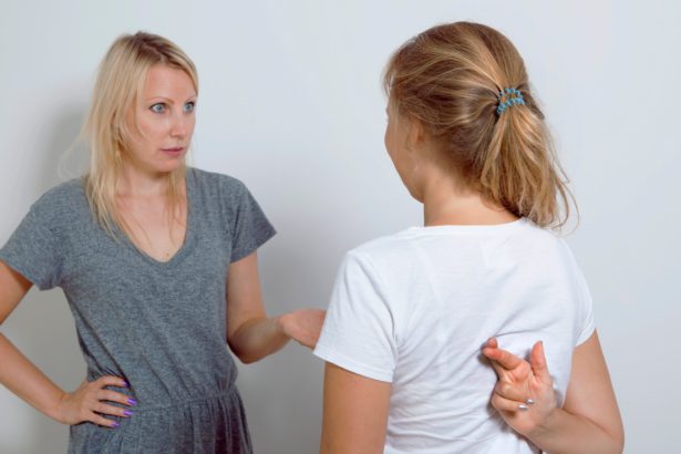 Mother asking her teenage daughter. Girl wants to lie to her parent and crossed her fingers.