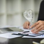 Professional businessman with hourglass sitting at office desk. Business and time management concept